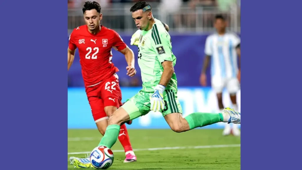 Argentina goalkeeper Emiliano Martinez clears the ball as Switzerland's Fabian Rieder closes him down in the FIFA World Cup 2026 quarter-final.