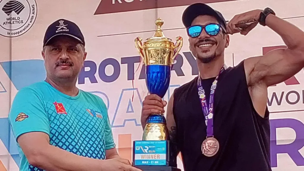 Clinton Tavares poses with the men's 21km winner's trophy after winning the Rotary Rain Run.